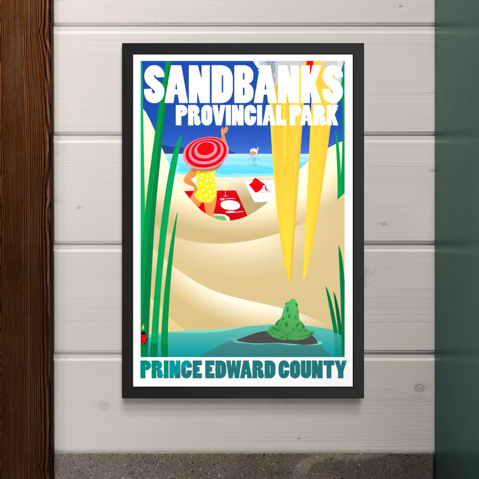 Framed poster of Sandbanks Provincial Park in Prince Edward County on a wooden wall.